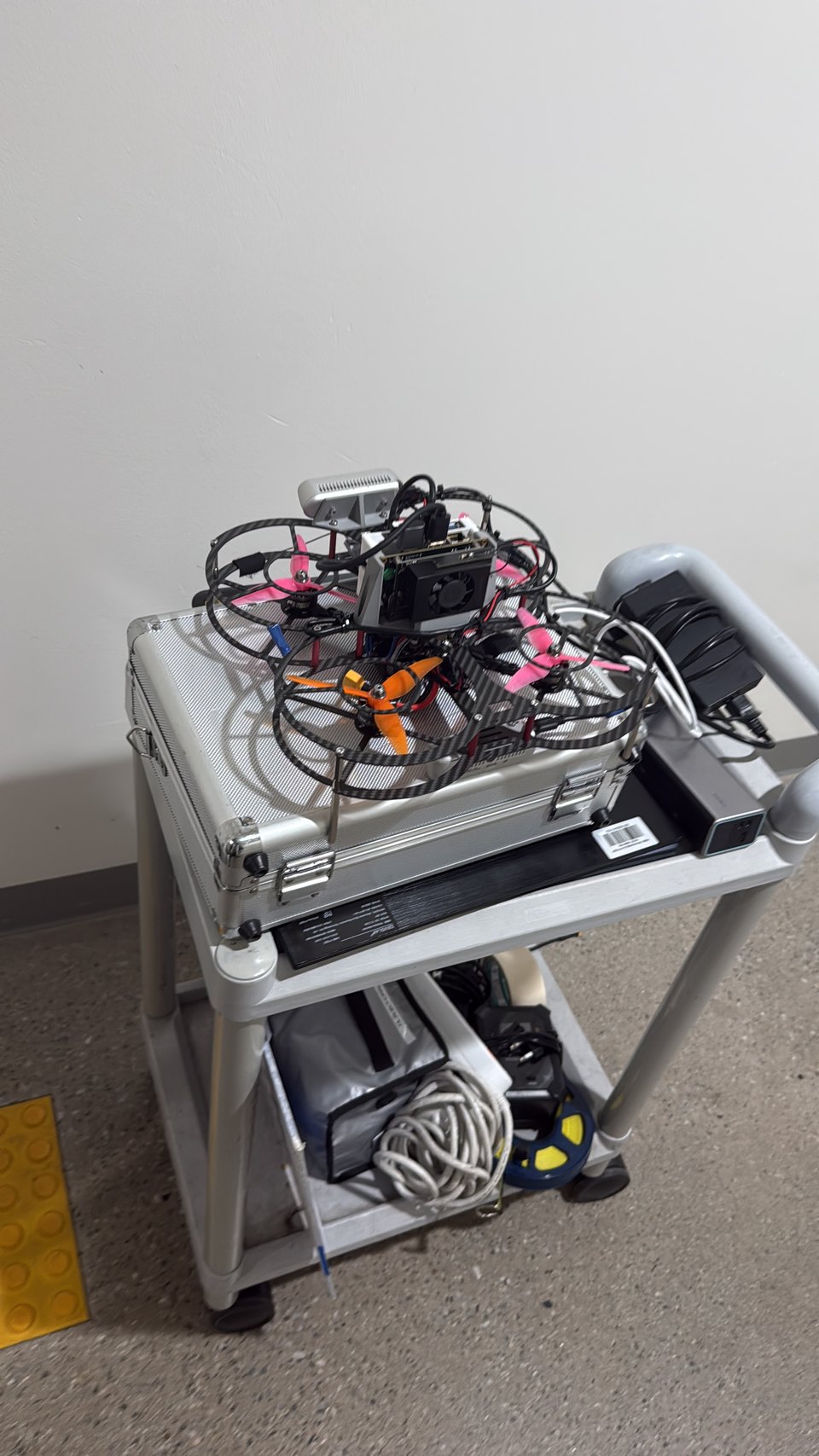 The quadrotor on a trolley: ducted prop guards, an onboard computer and two depth cameras strapped to the frame.