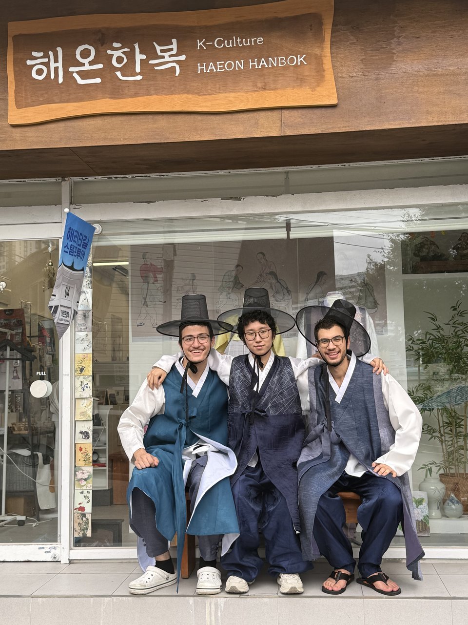 Abdullah and two friends in hanbok outside a rental shop.
