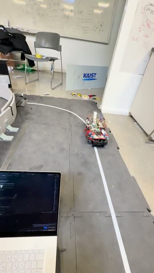 The car following a white line across a floor towards the starting grid.