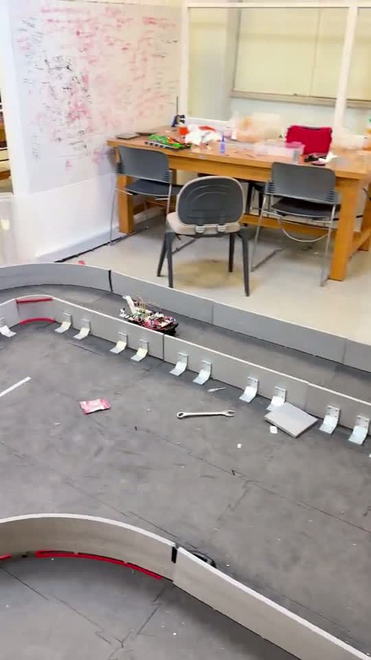 The self-driving car racing around a walled circuit, taking the corners without touching the barriers.